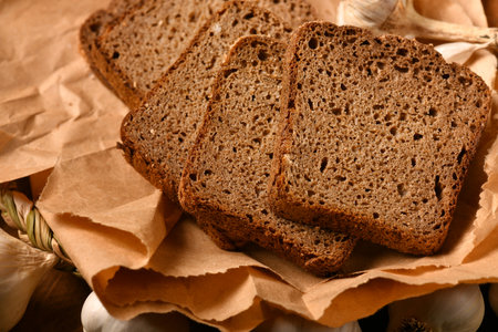 still life of food in a rural style on a dark wood background, rye bread and garlic, concept of...