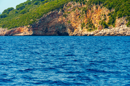 seascapes, a view of the rocks and a sea cave on the Bay of Kotor during a cruise on a ship in Montenegro, a bright sunny day, the concept of a summer tripの写真素材