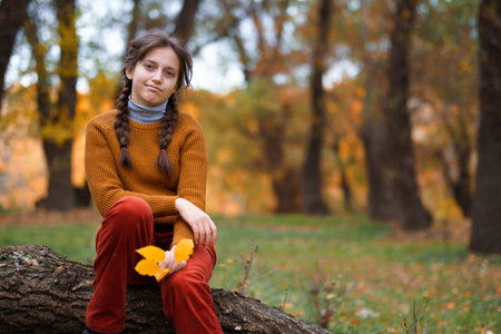 a young girl poses in autumn forest, fall season, beautiful natureの写真素材
