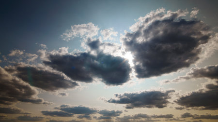 beautiful blue sky with dark dramatic cumulus clouds and sunlight for abstract background