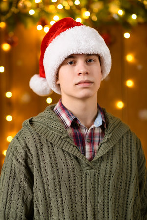 A teenage boy poses in the decorations for the New Year holiday, festive illumination and garland, decorationsの写真素材