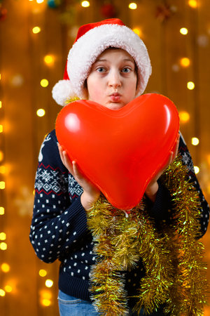 A teenage girl poses in New Year decorations with festive illumination and garlands, Christmas lights and decorations, Holiday themeの写真素材