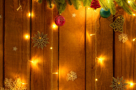 festive background of Christmas decorations with illumination, wooden boards and garlands, rustic style, New Year holidays themeの写真素材