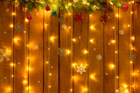 festive background of Christmas decorations with illumination, wooden boards and garlands, rustic style, New Year holidays themeの写真素材