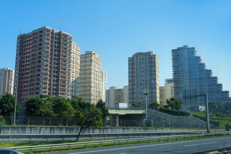 view of the city street and modern residential area with high-rise buildings, green lawn and...