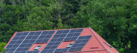 solar panels generating electricity on the roof of a house against the background of a green forest...