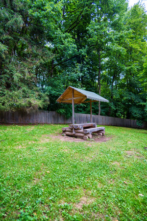 recreation area in the forest, gazebo with a bench and table in the middle of a clearingの写真素材