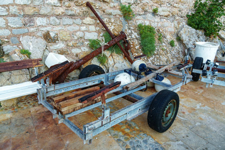 empty boat trailer on the embankment near an old stone wallの写真素材