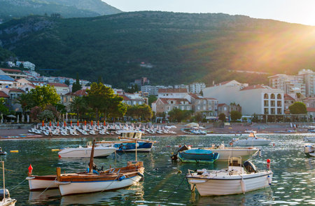 view of boats and city, sea and beach at dawn, panorama of Petrovac city, Montenegro, beautiful nature, hills covered with forest, hotels and beach with sun loungersの写真素材