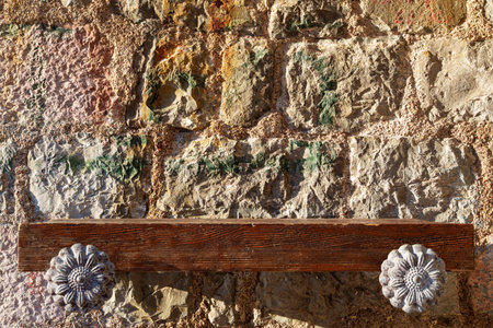 empty wooden shelf against old stone wall with contrasting sunlight as backgroundの写真素材