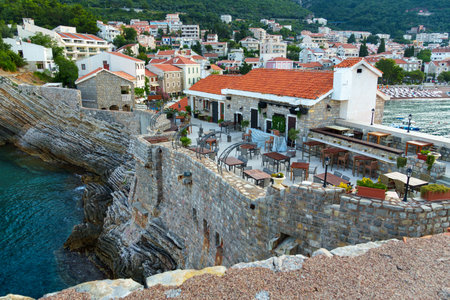 An outdoor cafe or restaurant with a panoramic view of Petrovac, Montenegro, is a great place to enjoy the scenery and relax.の写真素材