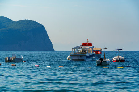 boats anchored in the sea, beautiful seascape with high hill covered with forest in the distance,...