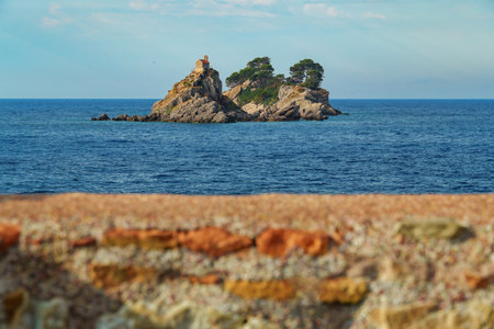 Beautiful seascape with sea view and islands with small church on top of cliff at sunset. The Sveta Nedelya and Katic Islands, near Petrovac city, Montenegroの写真素材
