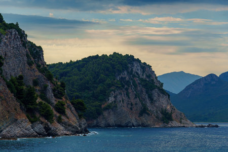 beautiful seascape, view of the sea and high cliff in the distance in the evening, near Petrovac city, Montenegroの写真素材