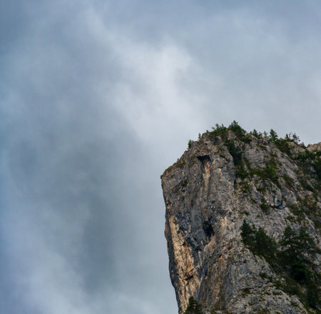 beautiful and dramatic landscape with mountains and forest against a cloudy skyの写真素材