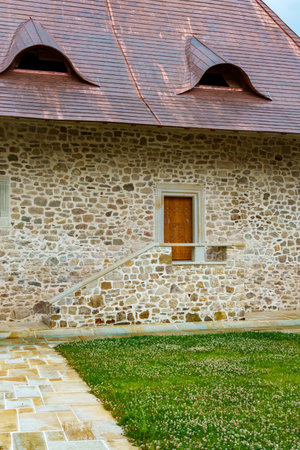 Stone stairs to porch with wooden door, stone building facade, beautiful architectural detailsの写真素材