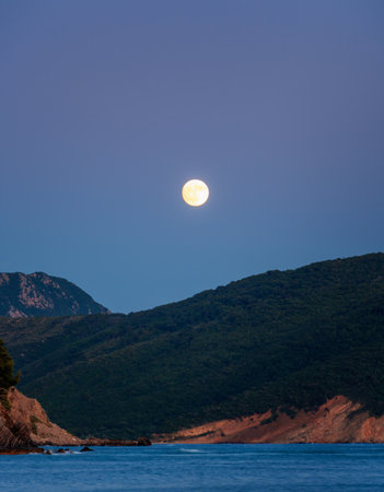 beautiful sunset over Adriatic sea, rocky coast and moonの写真素材