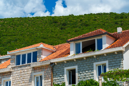 Old European architecture, view of facades of buildings in a resort town with stone walls and tiled roofs and open windows of penthouse on a bright sunny dayの写真素材