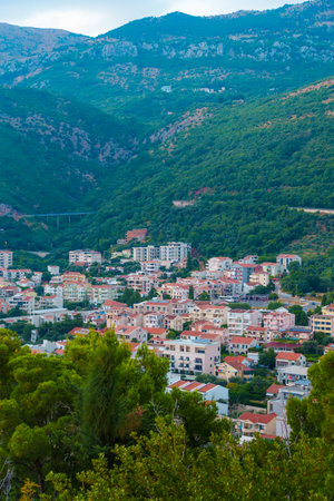 Panoramic view of resort town, Petrovac, Montenegro, from observation point during sunset, architecture and street lights, beautiful forested mountains, a beautiful resortの写真素材