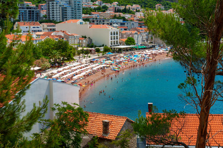 panorama of resort town with sea and beach, beautiful coastline and view of Adriatic sea in Petrovac, Montenegro, high forested hills and city architecture in backgroundの写真素材