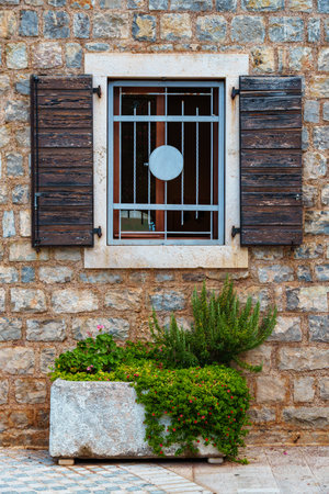 Old European architecture, view of the facade of a building in a resort town with stone walls and wooden shutters, on a bright sunny dayの写真素材