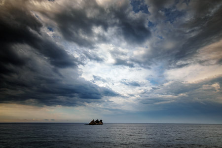 small islands far out to sea, cloudy, stormy sky, dramatic seascapeの写真素材