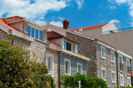 Old European architecture, a view of the facades of buildings in a resort town with stone walls and tiled roofs on a bright sunny day against a blue skyの写真素材