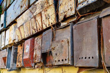 group of old mailboxes on the wall of a building, old weathered paintの写真素材