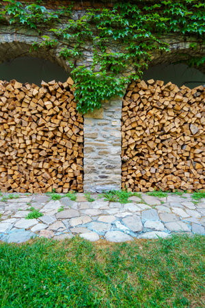 old stone wall with arches and green ivy filled firewood, close up of architectural details