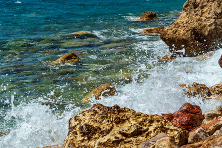 beautiful summer landscape of rocky sea coast, rocks on the edge of cliff, view onto water and waves, bright sunny dayの写真素材