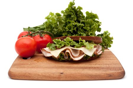 Healthy turkey breast sandwich on rye bread with vine ripe tomatoes and lettuce on white backgroundの写真素材