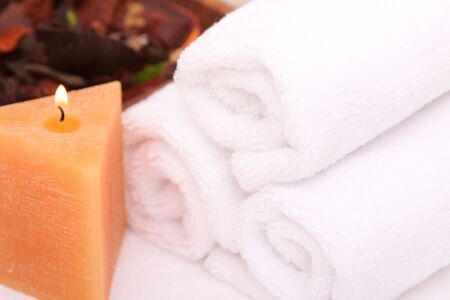 Spa candle with white rolled up towelsの写真素材