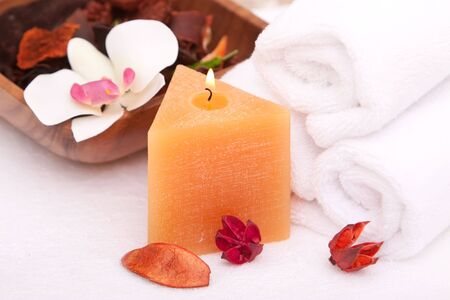 Spa candle with white rolled up towelsの写真素材