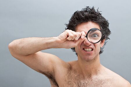 Curious man examining with magnifying glassの写真素材