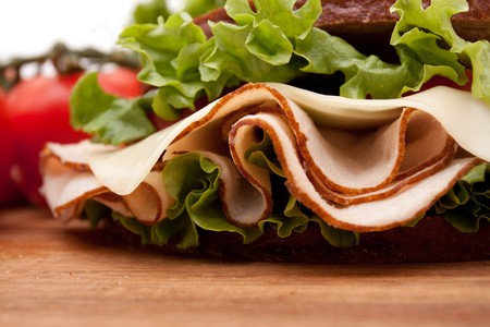 Healthy turkey breast sandwich on rye bread with vine ripe tomatoes and lettuce on white backgroundの写真素材