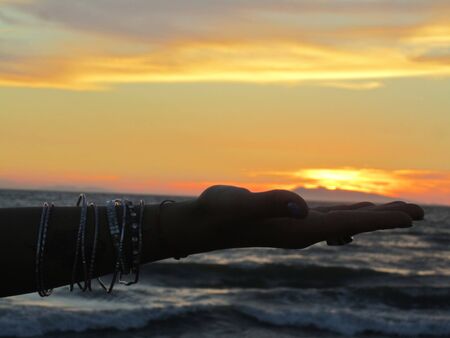 The hand holding the sunriseの写真素材