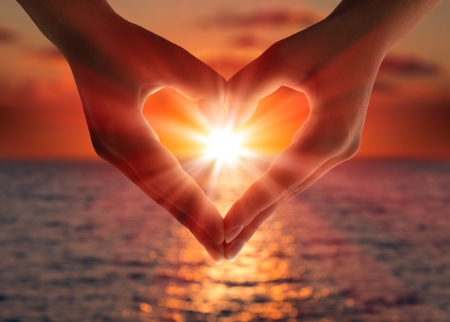 sunset in heart hands の写真素材