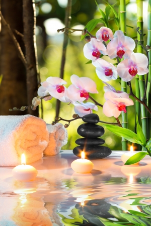 massage composition spa with candles, orchids, stones in garden の写真素材