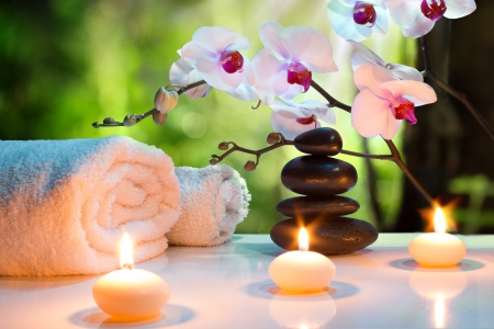 massage composition spa with candles, orchids, stones in garden の写真素材