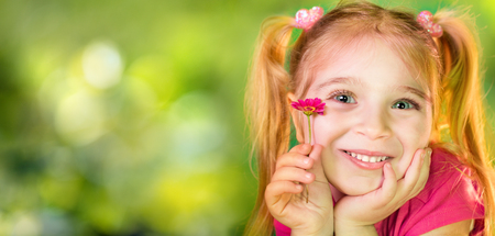 Cute Child With Purple Daisy In Spring Gardenの写真素材