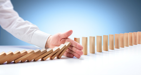 Problem Solving - Hand Stopping Domino Effectの写真素材