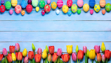 Easter Eggs And Tulips In Frame On Blue Table