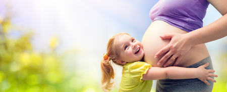 Happy Sister Hugging Pregnant Motherの写真素材