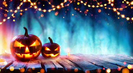 Halloween Party - Pumpkins And String Lights On Table In Dark Forestの写真素材