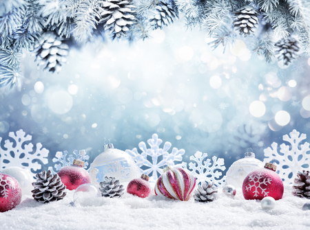 Christmas card - Baubles on snow with snowy fir branchesの写真素材