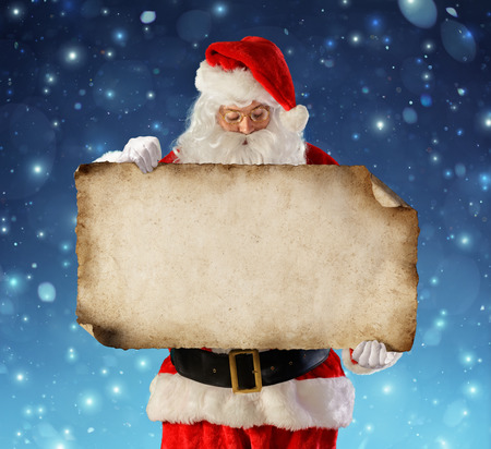 Santa Claus Reading Wish List In Snowy Nightの写真素材