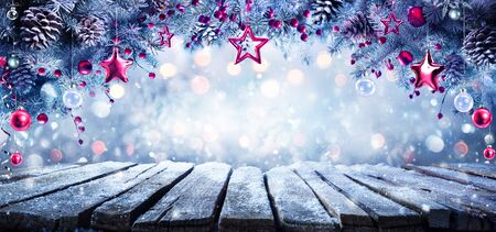 Christmas - Hanging Ornament On Cold Fir Branches With Frozen Tableの写真素材