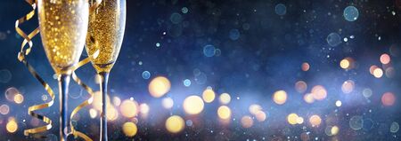 Abstract Celebration With Champagne Two Flutes With Defocused Christmas Lights In Blue Shiny Backgroundの写真素材
