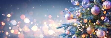 Christmas Tree With Golden Baubles And Shiny Lights In Blue Backgroundの写真素材