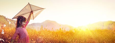 Little Girl With Kite In The Field At Sunsetの写真素材